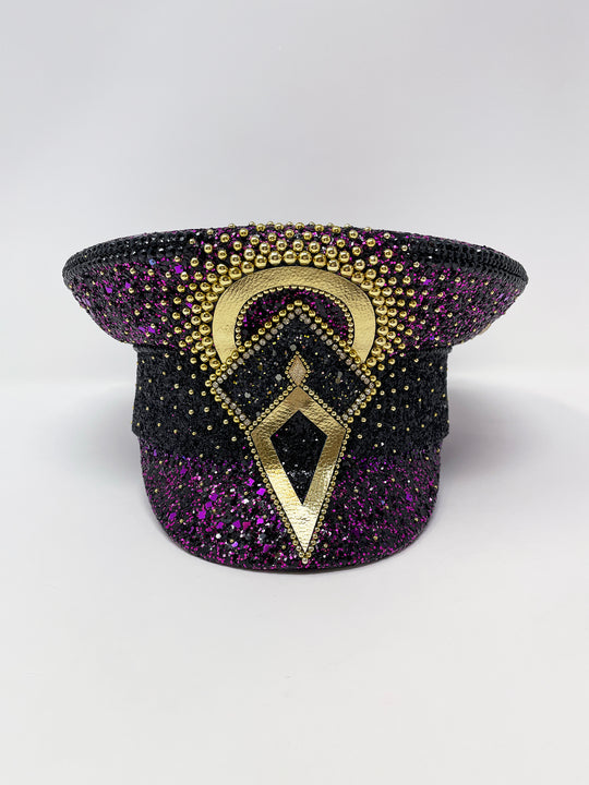 Hand embellished captain hat crafted from an authentic military hat, decorated with black and purple glitter, gold pearl like gems, rhinestones, crystals and geometric jewel detailing. Luxury stage, festival and statement fashion headwear. Handmade, rave, fully lined, high end fashion, costume hat