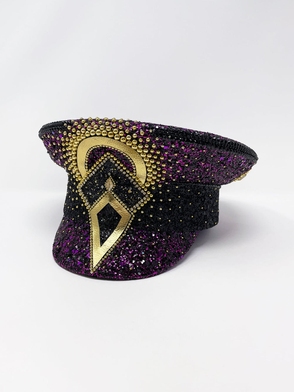 Hand embellished captain hat crafted from an authentic military hat, decorated with black and purple glitter, gold pearl like gems, rhinestones, crystals and geometric jewel detailing. Luxury stage, festival and statement fashion headwear. Handmade, rave, fully lined, high end fashion, costume hat