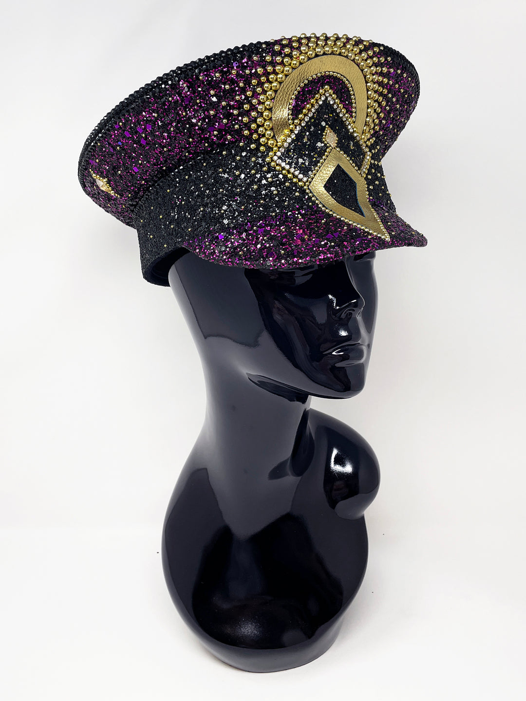 Hand embellished captain hat crafted from an authentic military hat, decorated with black and purple glitter, gold pearl like gems, rhinestones, crystals and geometric jewel detailing. Luxury stage, festival and statement fashion headwear. Handmade, rave, fully lined, high end fashion, costume hat