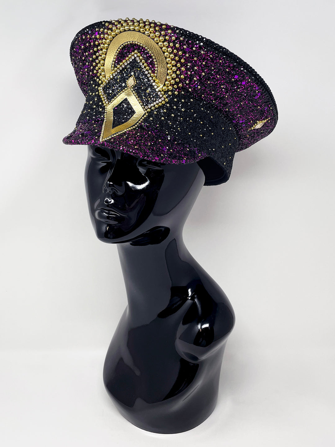 Hand embellished captain hat crafted from an authentic military hat, decorated with black and purple glitter, gold pearl like gems, rhinestones, crystals and geometric jewel detailing. Luxury stage, festival and statement fashion headwear. Handmade, rave, fully lined, high end fashion, costume hat