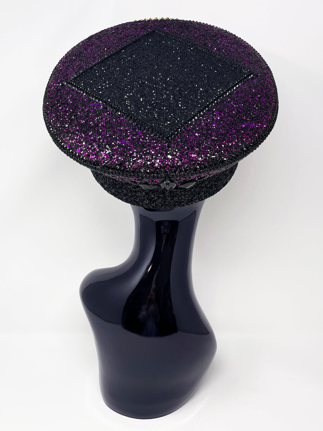 Hand embellished captain hat crafted from an authentic military hat, decorated with black and purple glitter, gold pearl like gems, rhinestones, crystals and geometric jewel detailing. Luxury stage, festival and statement fashion headwear. Handmade, rave, fully lined, high end fashion, costume hat