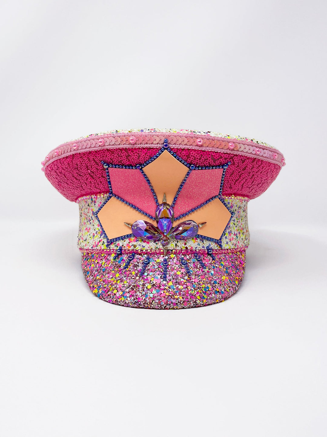 Festival captain hat with pink sequins, colourful glitter peak, Jukebox logo jewel detail, and glow-in-the-dark reflective starburst design – perfect for rave, costume, or party wear.
