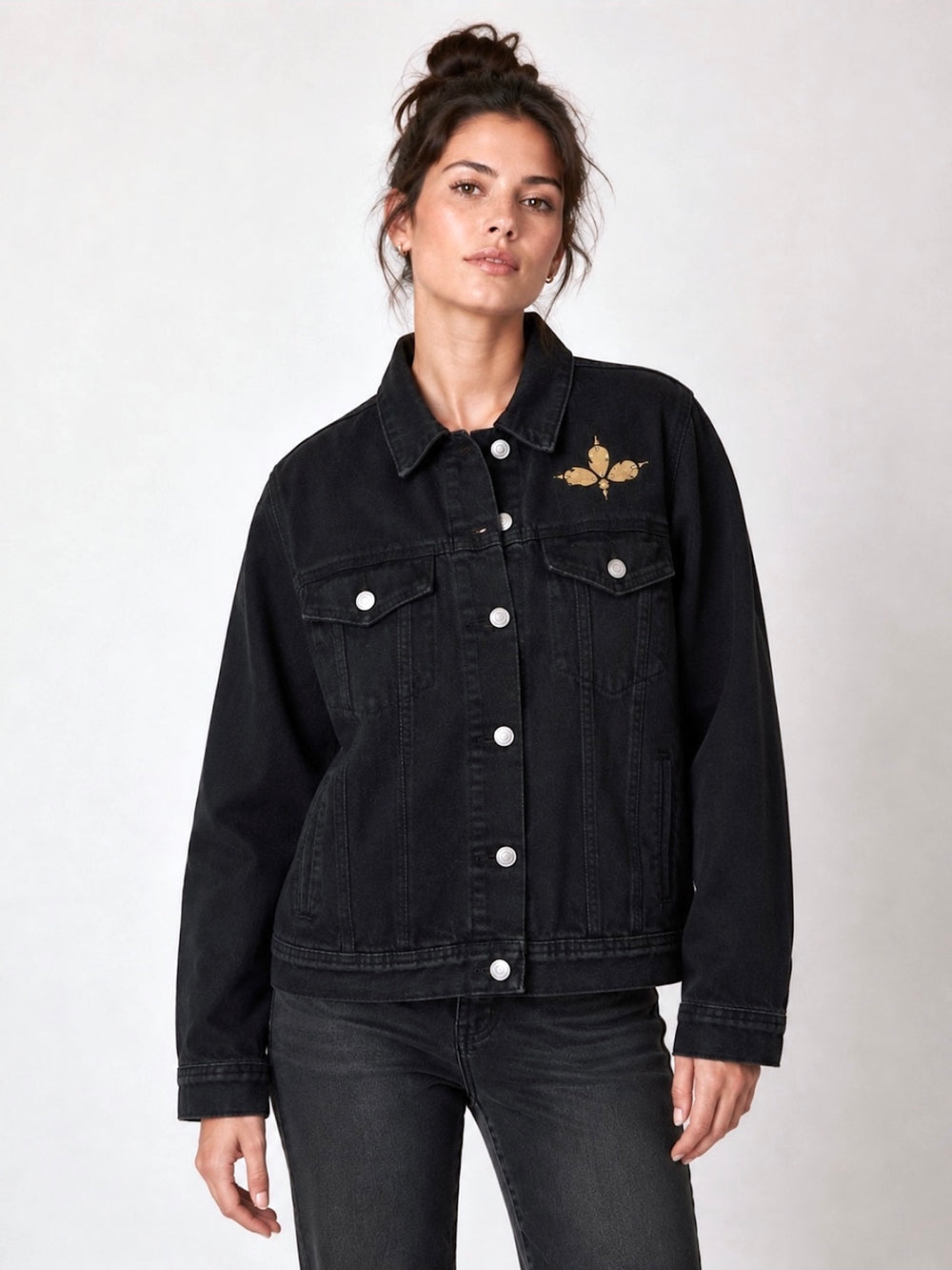 Black denim jacket featuring a black and gold leopard-print sequin appliqué with black tassel detailing across the back, styled on a model. Unique statement festival jacket by Jukebox Fashion. Rave jacket, party jacket, animal print