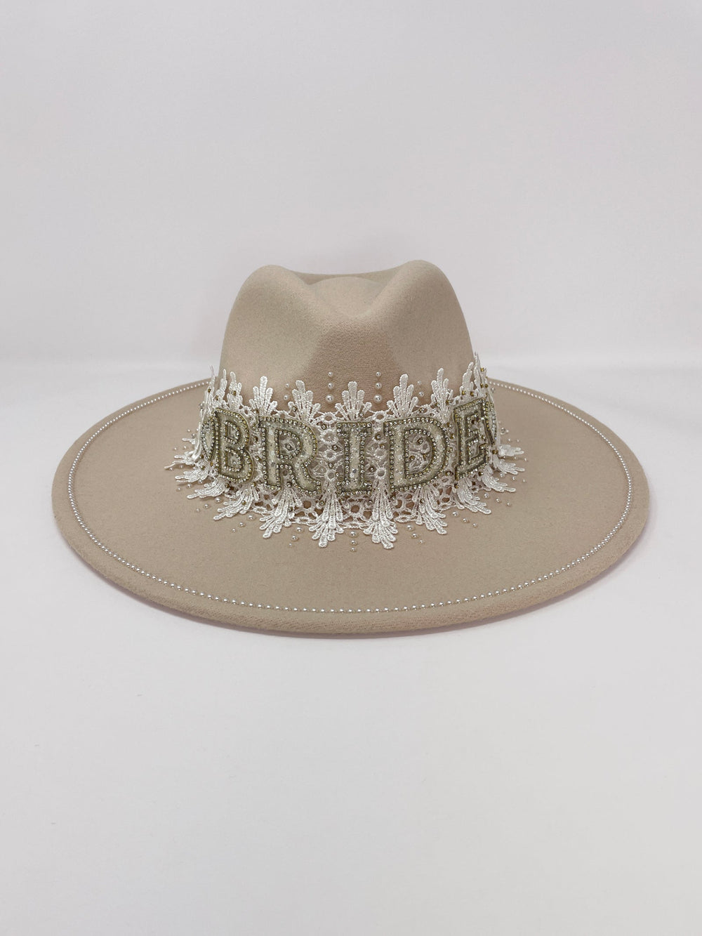 Beige fedora hat featuring interchangeable handmade lace bands with Velcro attachments. Includes three designs: “BRIDE” and “WIFEY” lettering embellished with crystals and pearls, and an elegant floral motif with lace, handmade  flowers and beaded details. A stylish 3-in-1 bridal accessory made in the UK. One size, wide brim fedora, luxury fedora, bride hat, wifey hat, floral hat, hen do