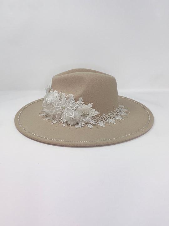Beige fedora hat featuring interchangeable handmade lace bands with Velcro attachments. Includes three designs: “BRIDE” and “WIFEY” lettering embellished with crystals and pearls, and an elegant floral motif with lace, handmade  flowers and beaded details. A stylish 3-in-1 bridal accessory made in the UK. One size, wide brim fedora, luxury fedora, bride hat, wifey hat, floral hat, hen do