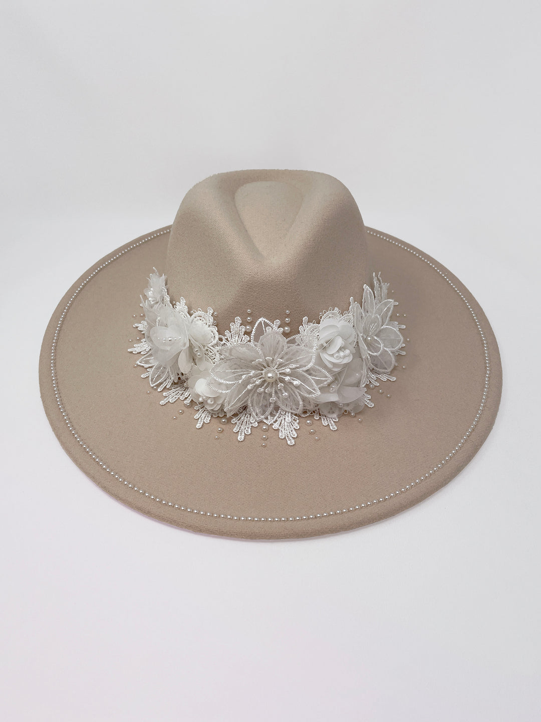 Beige fedora hat featuring interchangeable handmade lace bands with Velcro attachments. Includes three designs: “BRIDE” and “WIFEY” lettering embellished with crystals and pearls, and an elegant floral motif with lace, handmade  flowers and beaded details. A stylish 3-in-1 bridal accessory made in the UK. One size, wide brim fedora, luxury fedora, bride hat, wifey hat, floral hat, hen do