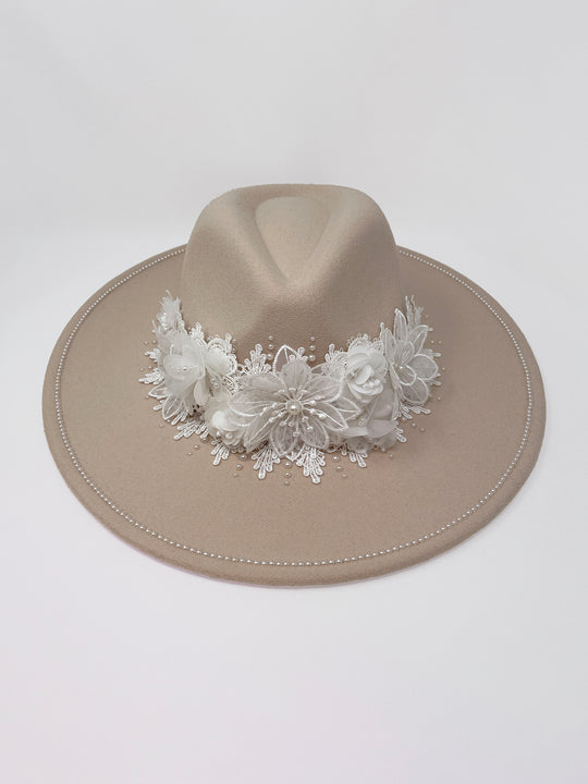 Beige fedora hat featuring interchangeable handmade lace bands with Velcro attachments. Includes three designs: “BRIDE” and “WIFEY” lettering embellished with crystals and pearls, and an elegant floral motif with lace, handmade  flowers and beaded details. A stylish 3-in-1 bridal accessory made in the UK. One size, wide brim fedora, luxury fedora, bride hat, wifey hat, floral hat, hen do