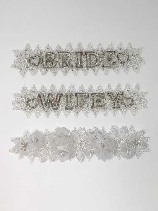Beige fedora hat featuring interchangeable handmade lace bands with Velcro attachments. Includes three designs: “BRIDE” and “WIFEY” lettering embellished with crystals and pearls, and an elegant floral motif with lace, handmade  flowers and beaded details. A stylish 3-in-1 bridal accessory made in the UK. One size, wide brim fedora, luxury fedora, bride hat, wifey hat, floral hat, hen do
