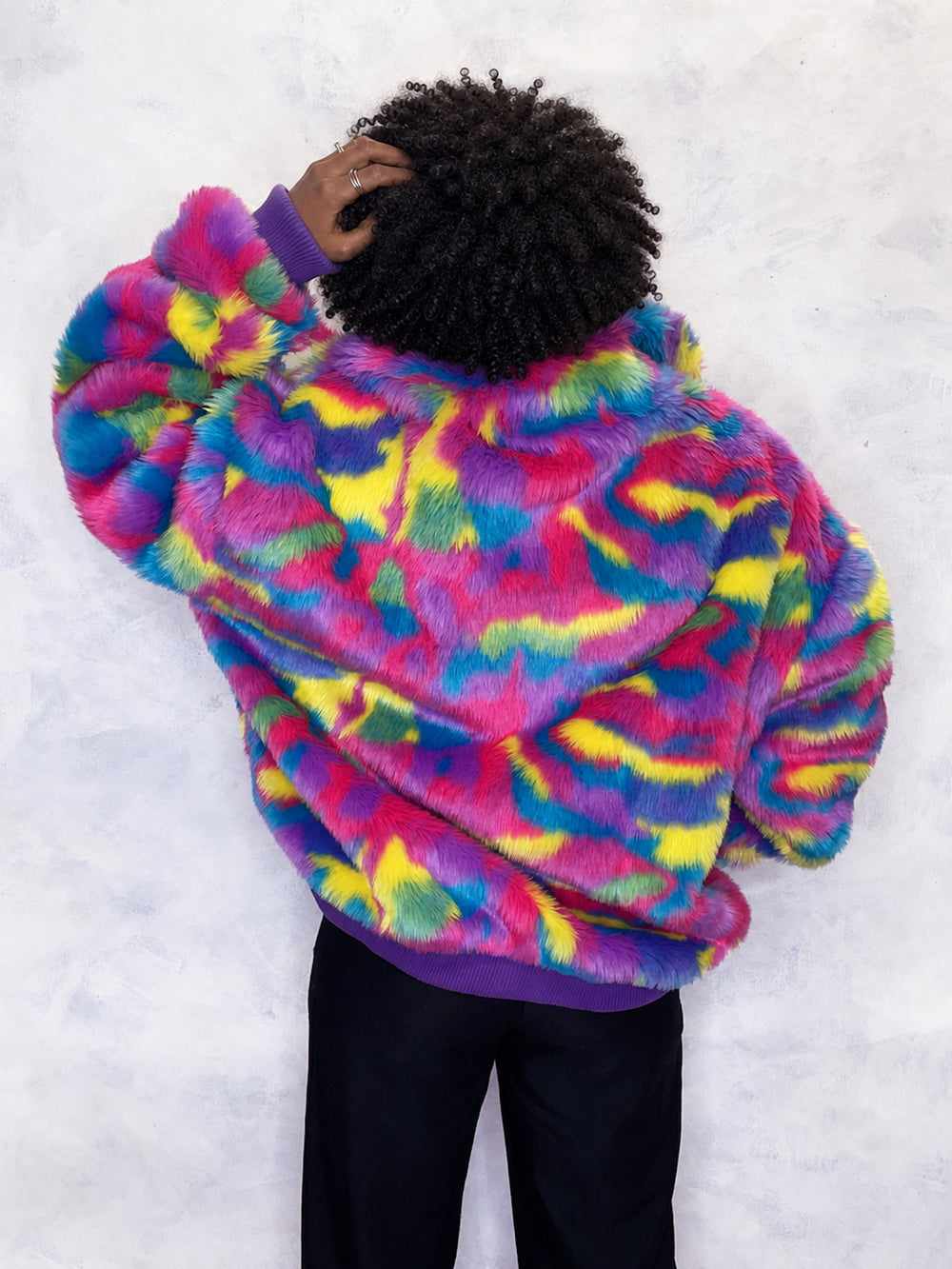 Vibrant multi-coloured faux fur bomber jacket made in the UK, featuring a mix of pink, blue, yellow, green and purple tones. The jacket is fully lined with side pockets, a high collar, and a front zip fastening. ribbed cuffs and waistband. Winter coat, party jacket, festival fur, bright bomber jacket
