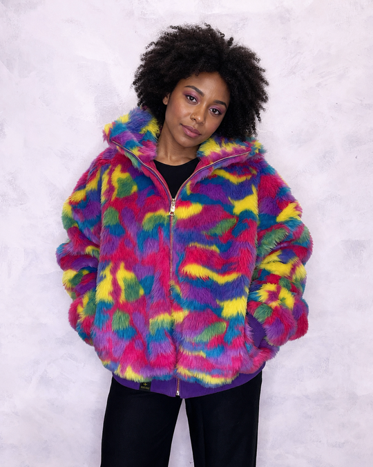 Vibrant multi-coloured faux fur bomber jacket made in the UK, featuring a mix of pink, blue, yellow, green and purple tones. The jacket is fully lined with side pockets, a high collar, and a front zip fastening. ribbed cuffs and waistband. Winter coat, party jacket, festival fur, bright bomber jacket