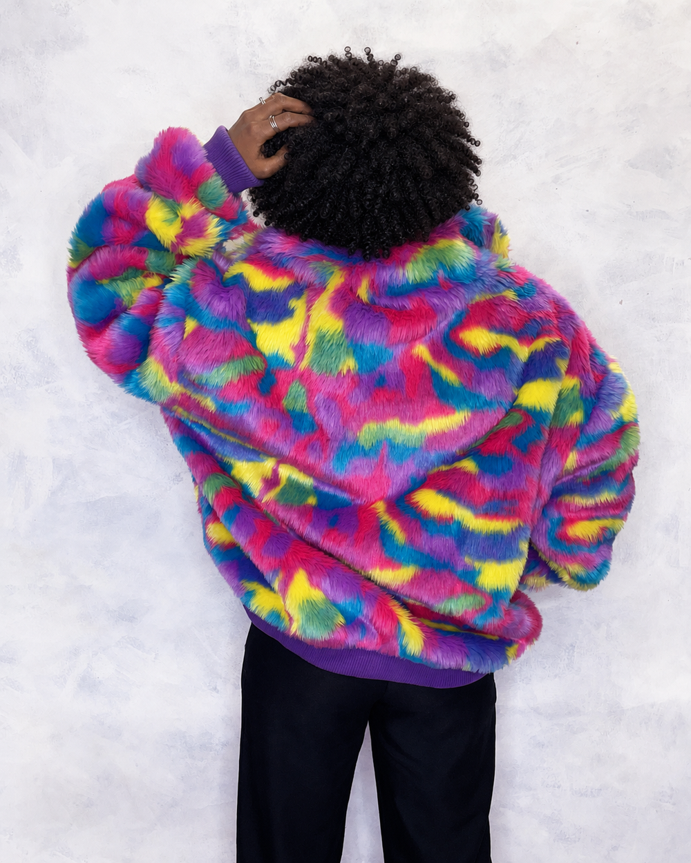 Vibrant multi-coloured faux fur bomber jacket made in the UK, featuring a mix of pink, blue, yellow, green and purple tones. The jacket is fully lined with side pockets, a high collar, and a front zip fastening. ribbed cuffs and waistband. Winter coat, party jacket, festival fur, bright bomber jacket
