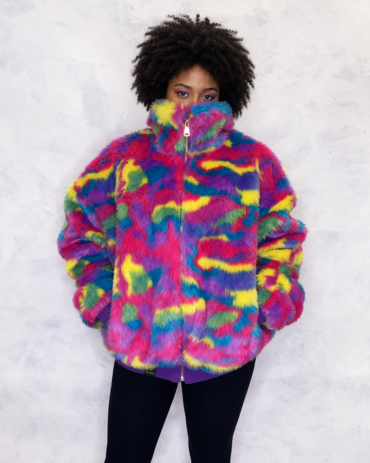 Vibrant multi-coloured faux fur bomber jacket made in the UK, featuring a mix of pink, blue, yellow, green and purple tones. The jacket is fully lined with side pockets, a high collar, and a front zip fastening. ribbed cuffs and waistband. Winter coat, party jacket, festival fur, bright bomber jacket