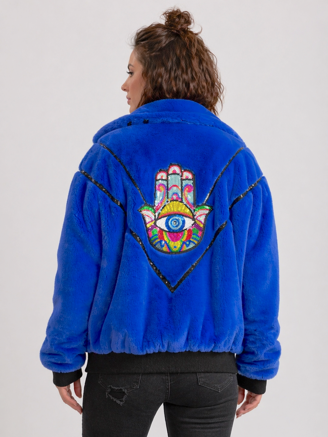 Handmade electric blue faux fur bomber jacket with colourful sequin Hamsa hand appliqué on the back, black sequin V detailing, soft collar, black ribbed cuff and waistband, front zip fastening and side pockets. Festival coat, party jacket, royal blue
