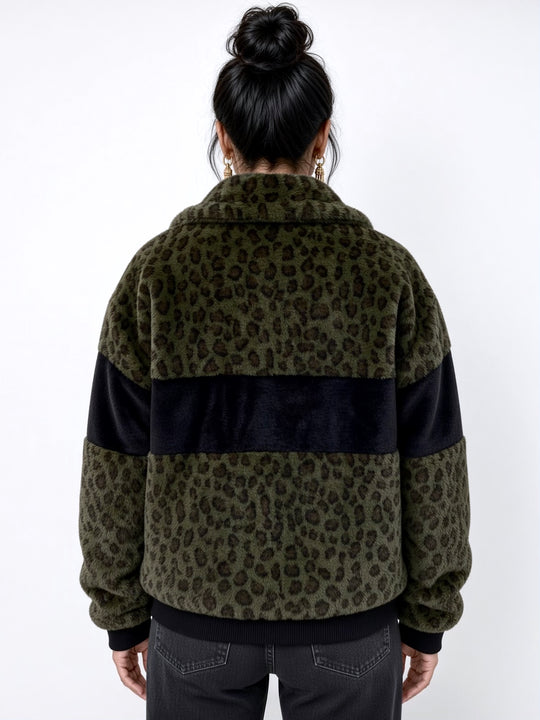 Forest green leopard print faux fur bomber jacket with contrasting black panels, oversized collar, front zip fastening, pockets and ribbed cuffs and ribbed waistband. Modelled with black ripped jeans. Plush faux fur, festival jacket, winter coat