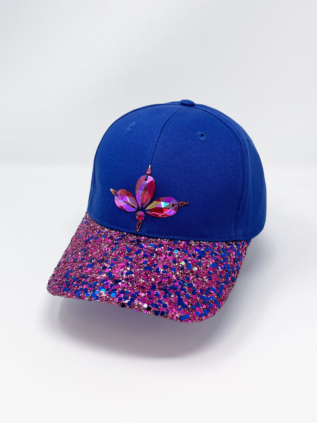Blue curved peak cap with an embellished vibrant pink and blue glitter mix peak and 3D Jukebox logo emblem centre front, stylish streetwear, eye catching accessory, adjustable, velcro back, party hat, festival hat, urban, unique headwear, made in the UK