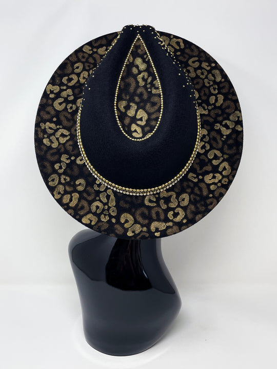 Short Brim black fedora hat, hand painted leopard print in metallic gold tones, with a gold metal and crystal leopard centre motif, embellished with gold pearl like rhinestones and crystals. gold splash, luxury fedora, made in the uk, handmade, statement hat, high end fashion, festival fedora, ibiza hat