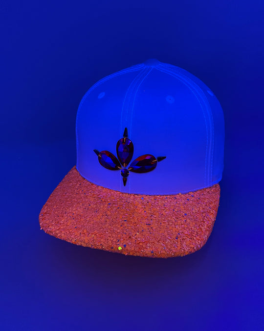 White flat peak cap with UV neon orange glitter peak. 3D Jukebox logo emblem centre front, stylish streetwear, eye catching accessory, adjustable, snapback, party hat, festival hat, rave, urban, crystals, Halloween, festival fashion, glow, rhinestones, unique headwear, made in the UK