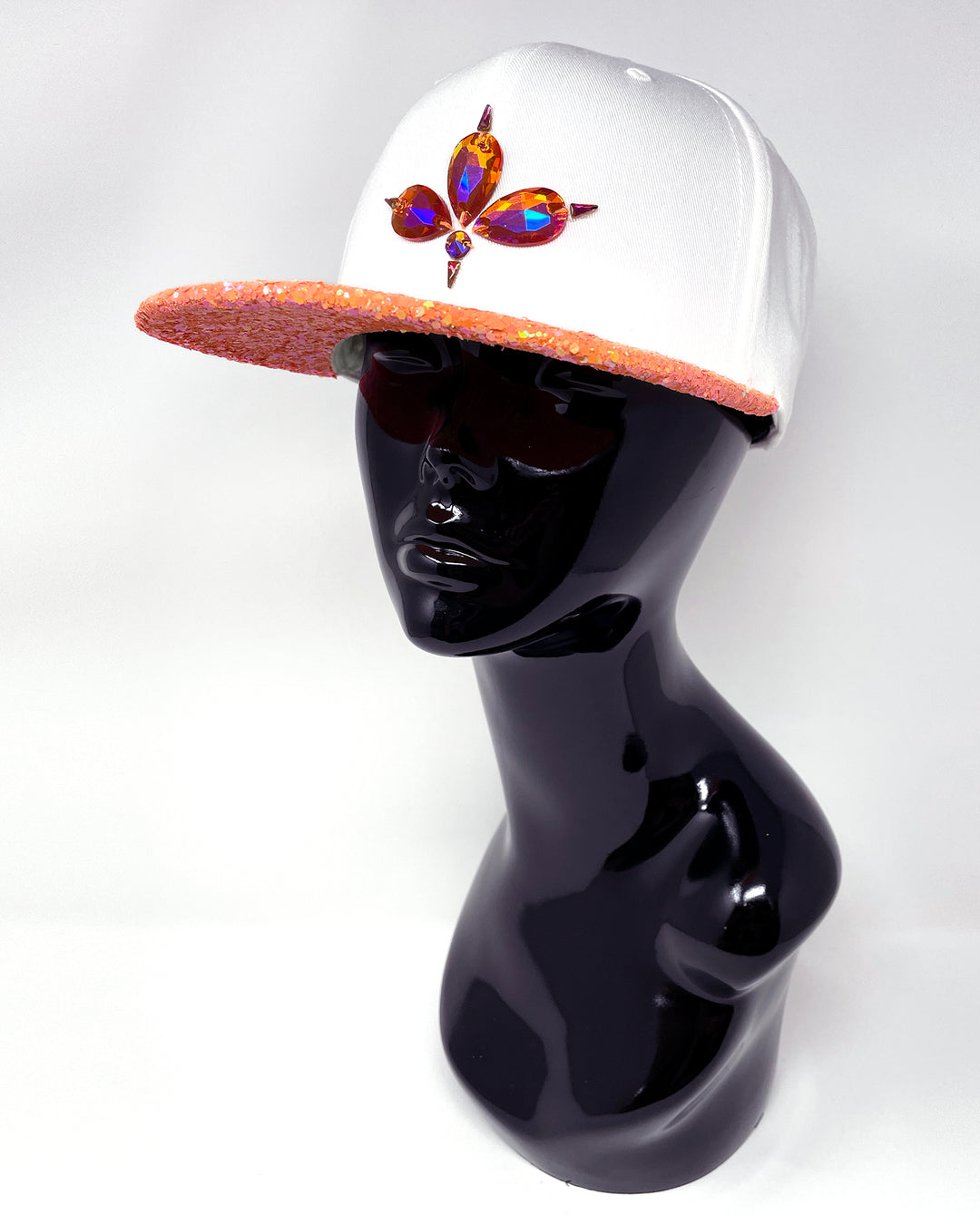 White flat peak cap with UV neon orange glitter peak. 3D Jukebox logo emblem centre front, stylish streetwear, eye catching accessory, adjustable, snapback, party hat, festival hat, rave, urban, crystals, Halloween, festival fashion, glow, rhinestones, unique headwear, made in the UK
