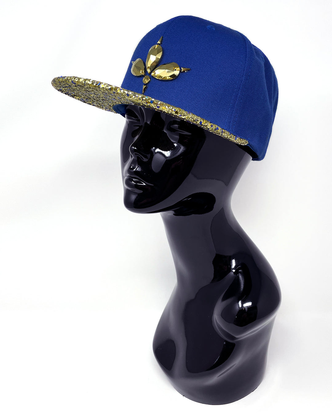 Blue flat peak cap with a gold and blue glitter mix peak. 3D Jukebox logo emblem centre front, stylish streetwear, eye catching accessory, adjustable, snapback, party hat, festival hat, rave, urban, crystals, festival fashion, rhinestones, unique headwear, made in the UK